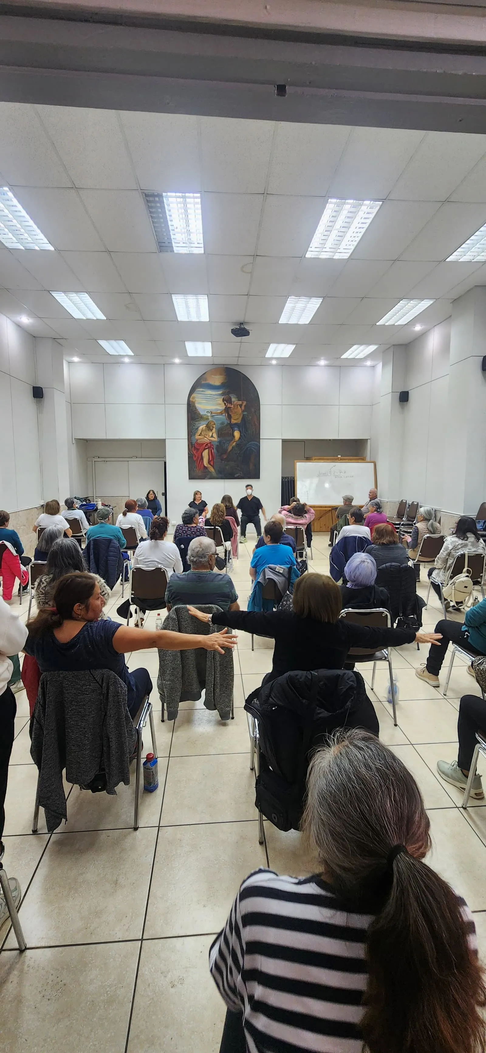 Grupo en clase con los brazos extendidos