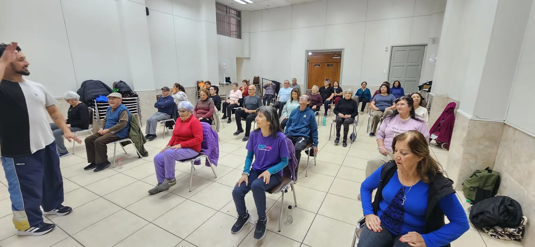 Kinesiólogo guiando una clase grupal de movimiento